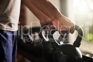 When life gives you health grab it with both hands. an unrecognisable man working out with a kettle bell in a gym.