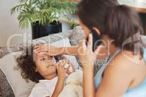 Healthcare, family and sick little child suffering from fever, flu and cold and mother checking temperature of her ill son while calling a doctor. Kid lying on sofa showing signs of virus disease