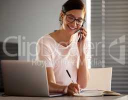 Yes I have a pen and paper with me. a young woman making a phone call using her smartphone while working from home.