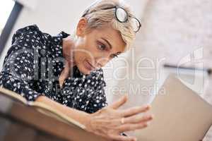 A faster internet connection would surely help. a mature woman sitting alone and feeling stressed while using her laptop to work from home.