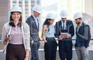 If you hire us, you can expect exceptional results. a businesswoman wearing a hardhat while standing outside with her colleagues.