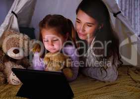 Just one more episode before bedtime. a little girl and her mother watching something on a digital tablet at night.