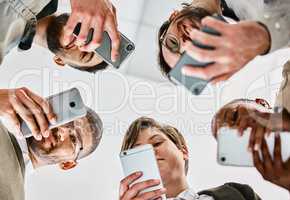 Hungry eyes, follow me. a group of young businesspeople using their cellphones against a white background.
