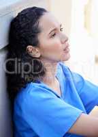 Silence speaks. a beautiful young doctor looking defeated and stressed outside in the city.