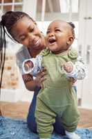 Hell be walking in no time. a young woman bonding with her baby at home.