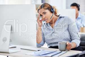 Tired, frustrated and stressed call center agent with a headache while working in customer service. Female IT support assistant struggling with a migraine and feeling confused or anxious