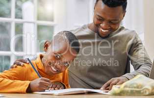 Dad always helps me the best. a young father helping his son with homework at home.