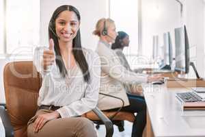 Solving problems one call at a time. Cropped portrait of an attractive young female call center agent wearing a headset and giving thumbs up while working in her office.