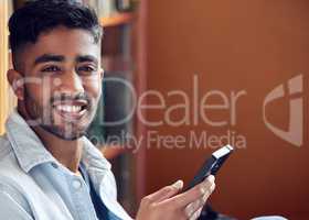 Whatever you do, do it smartly. a young man using a smartphone in a library at university.