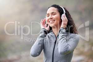 Now this is what I call a good workout playlist. a fit young woman wearing headphones while out in the mountains.