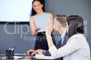 Id like to make a suggestion... a young businesswoman raising her hand during a meeting in an office.