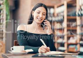 Beautiful, young and friendly woman talking on the phone and writing in a dairy at a coffee shop. Confident freelancer booking appointments and smiling on call in a restaurant on a summer weekend