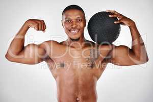 Something left, a fortress to defend. Studio shot of a shirtless handsome young man exercising with weights against a white background.