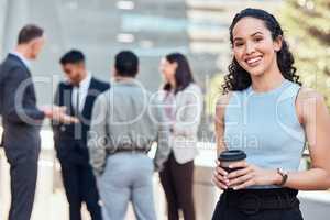 Let me introduce you to my team. an attractive young businesswoman standing outside while her colleagues stand behind her.