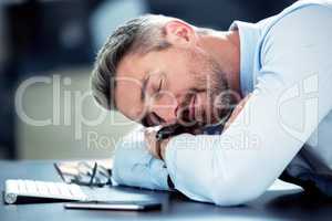 Ive had a long week. a mature businessman sleeping with his head on his desk.