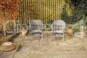 Garden chairs, furniture and seating in a secluded and peaceful courtyard or home backyard. Handmade, craft and rustic wicker patio seats to relax, enjoy and meditate in zen and calm nature