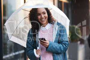 Without rain thered be no flowers. a young woman using a phone while holding an umbrella in the city.