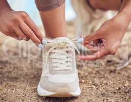 Making sure they fit comfortably around my feet. Closeup shot of an unrecognisable woman tying her shoelaces while exercising outdoors.