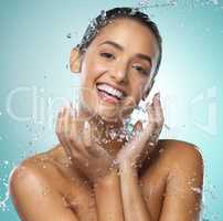 Now thats some sensational skin. a young woman taking a shower against a blue background.
