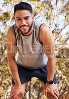 Smile and keep going. a handsome young man taking a moment to catch his breath during his outdoor run.
