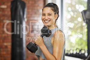 Muscle definition is what Im after. Portrait of a sporty young woman exercising with a dumbbell in a gym.