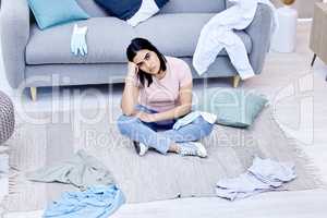 A messy environment creates a messy mind. a young woman cleaning her lounge at home.