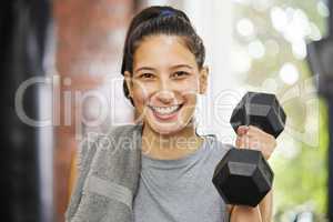 Boost your health and fitness today. Portrait of a sporty young woman exercising with a dumbbell in a gym.