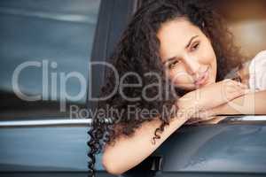 A road trip is the perfect escape. a beautiful young woman leaning out the car window.