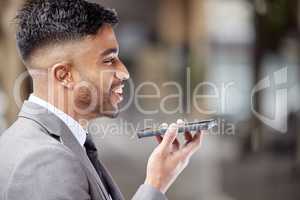 Voice notes are easier than texting. a handsome young businessman standing in the city and using his cellphone.