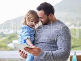 Youre such a clever girl. a young father using a digital tablet with his daughter at home.