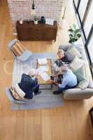 You have to be aware of this. Aerial shot of a group of businesspeople going through paperwork.