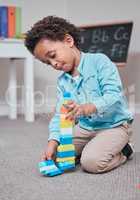 I want to have the tallest building in the city. a young boy playing with building blocks in a room.