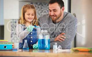 Only a few drops are necessary. a little girl completing scientific experiments with her dad at home.