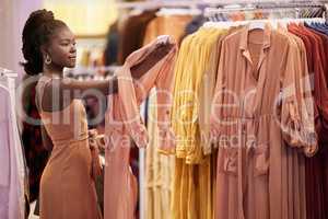 You cant keep buying the same thing. a young woman looking at items on a clothing rail in a boutique.