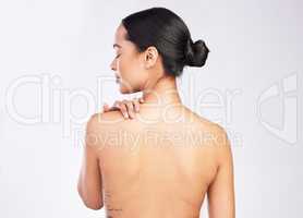 Always remember to take care of your body. Rearview shot of a young woman posing with her hand on her shoulder.