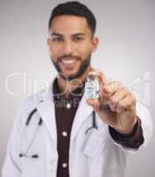 A life-saver in a bottle. a handsome young doctor standing alone in the studio and holding a vial of the Covid vaccine.