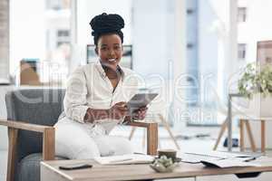 Excited for new business ventures. a businesswoman using her digital tablet at work.