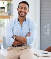 Hes an optimistic guy. Portrait of a confident young businessman standing with his arms crossed in an office.