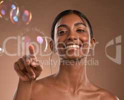 Was I was supposed to hold out darling. Portrait of a young attractive woman posing with bubbles against a brown background.