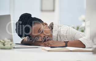 This day has worn me out. a young businesswoman taking a nap on her desk at work.