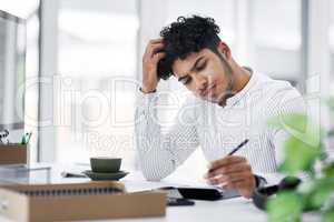 Why dont these figures all add up. a young businessman looking stressed out while using a calculator in an office.