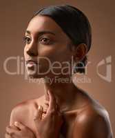 Break yourself against my stones. Side shot of a beautiful young woman posing against a brown background.