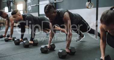 Building excellent upper body strength. a group of sporty young people exercising with dumbbells in a gym.