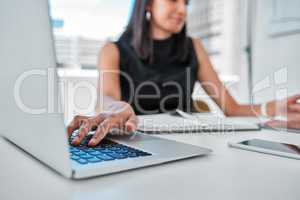 Grateful for my touch typing skills. an unrecognizable businesswoman sitting alone in the office and using technology.