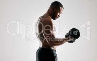 Winners find a way, losers find an excuse. Studio shot of an young man working out with a dumbbell against a grey background.
