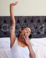 More sleep, please. a young woman stretching in her bed after waking up.