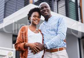 Starting parenthood in our new place. Portrait of a young couple standing outside their new home.