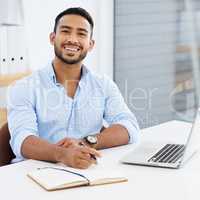 Dedication and determination lead to success. a young businessman writing in a notebook at work.