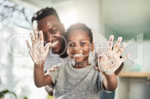 Say farewell to filth, and hello to good health. Portrait of a boy holding up his soapy hands while standing in a bathroom with his father at home.