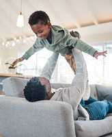 Who needs a workout when playtime is just as energetic. an adorable little boy having fun with his father on the sofa at home.